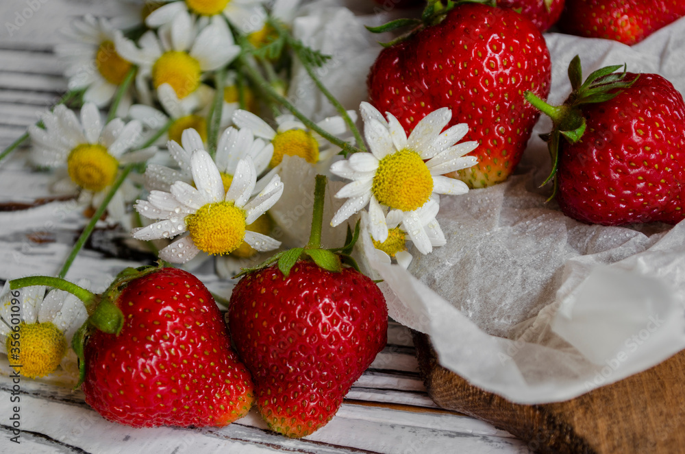 fresh strawberries on a light background with daisies fresh strawberries on a light background with daisies