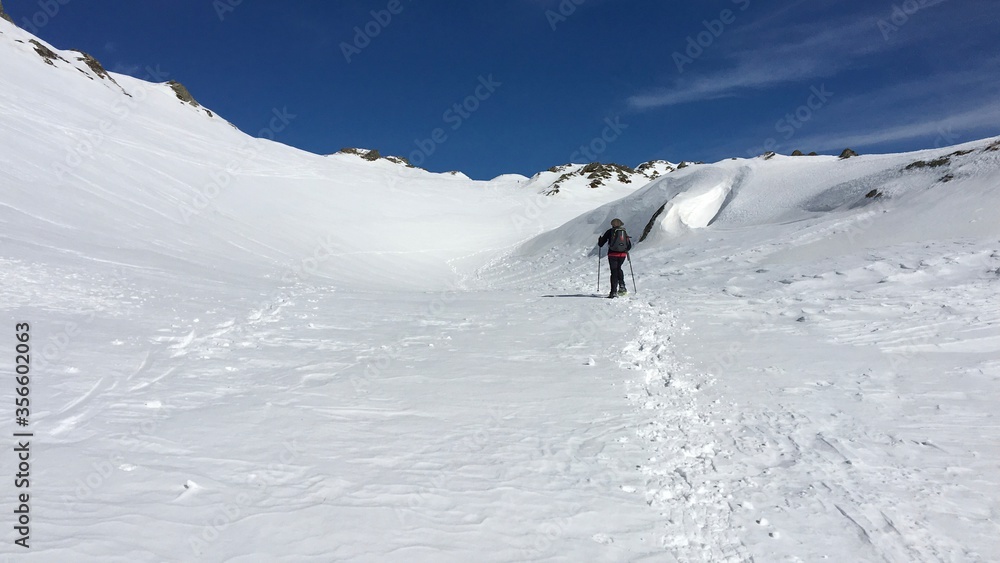 Some hikers in the snowy valley in the mountains of the Simplon pass in Switzerland.