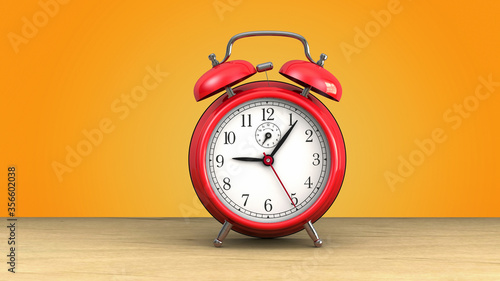 retro red alarm clock at 9 o' clock on orange background.