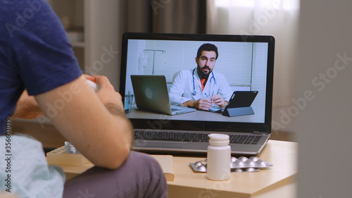 Man sitting on sofa on an online medicine consultation during covid lockdown