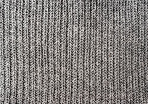 Gray knitted texture like on a woolen sweater or on a warm scarf. Type of knitting - stocking.