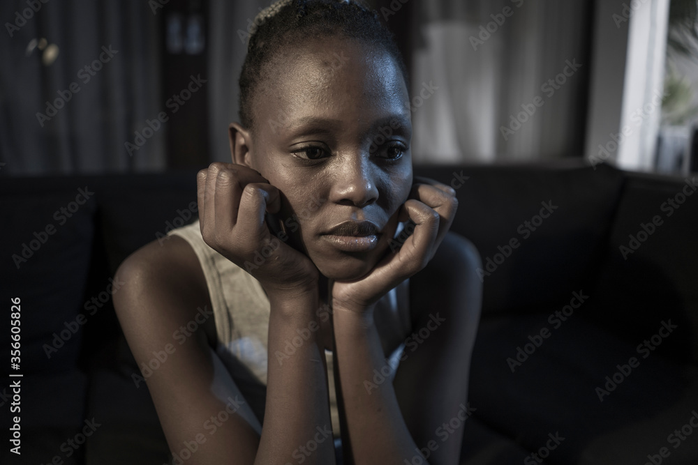 Millennial generation afro American girl at night suffering depression - young attractive sad and depressed black woman sitting thoughtful and worried on sofa Millennial generation afro American girl at night suffering depression - young attractive sad and depressed black woman sitting thoughtful and worried on sofa