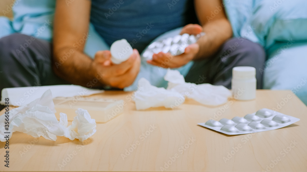 Close up of sick man checking his pills during covid-19 quarantine. Close up of sick man checking his pills during covid-19 quarantine.