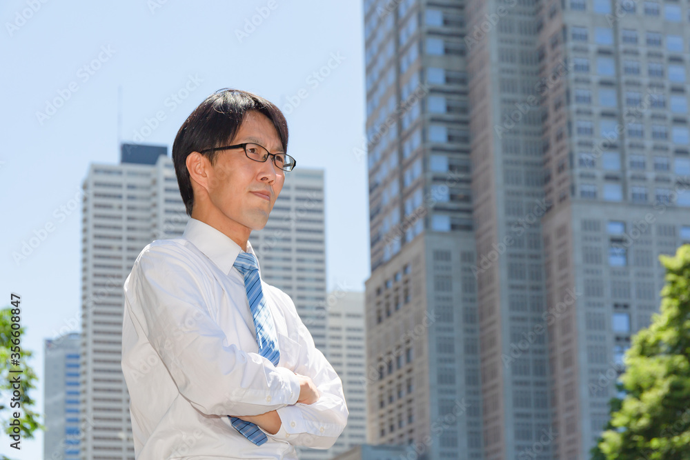 やせ型の真面目そうな日本人ビジネスマンが腕組みしている やせ型の真面目そうな日本人ビジネスマンが腕組みしている