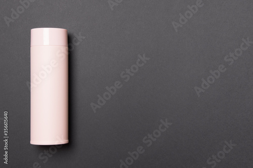 pink thermos cup on black background with copy space