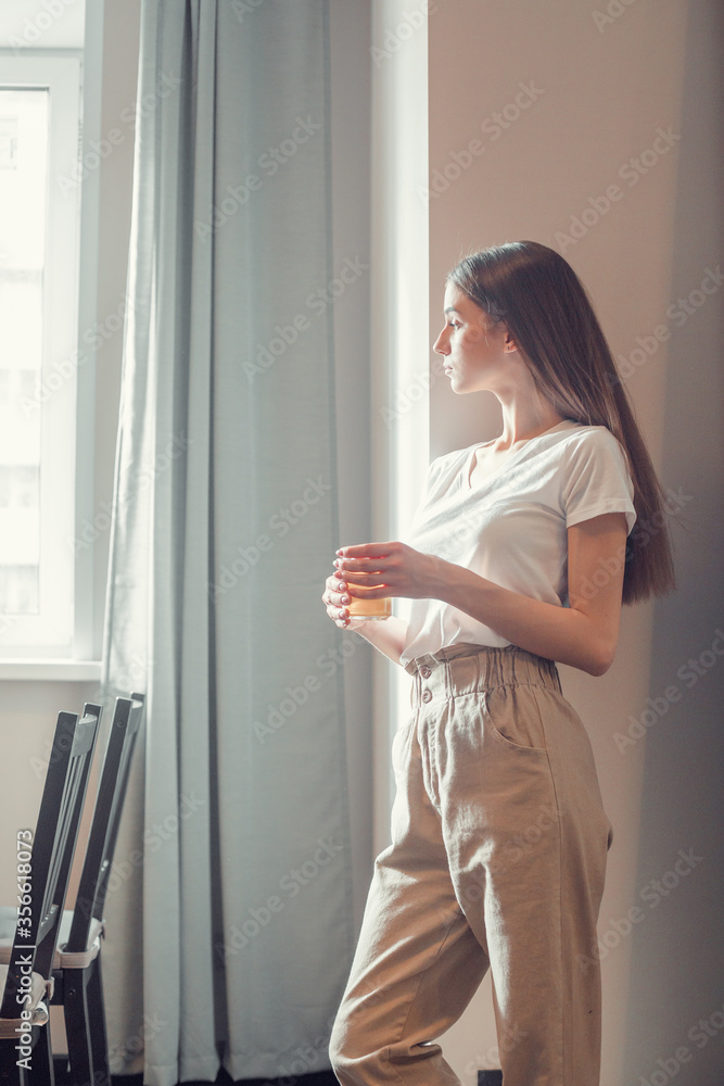 Beautiful woman drinking morning tea behind window Beautiful woman drinking morning tea behind window