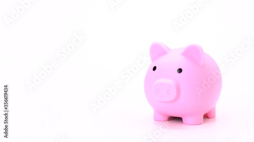hand putting coin into pig doll bank on white background for title or end credit - vdo 4k, 1080, fhd, full hd.  saving money on pink piggy bank isolate with free space for text, copy or graphic.