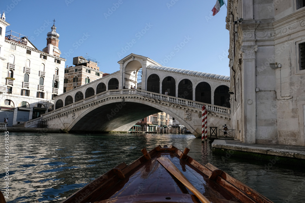 Venice, Italy. View of Rialto's Bridge with no tourists from a traditional venetian boat during coronavirus outbreak.