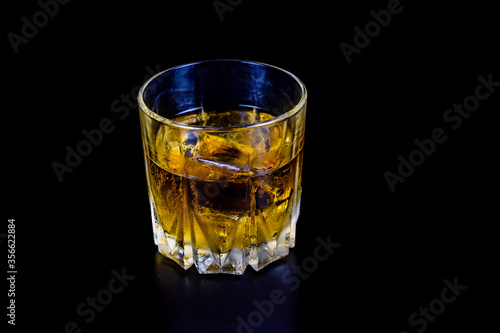 Glass of whiskey isolated on the black background