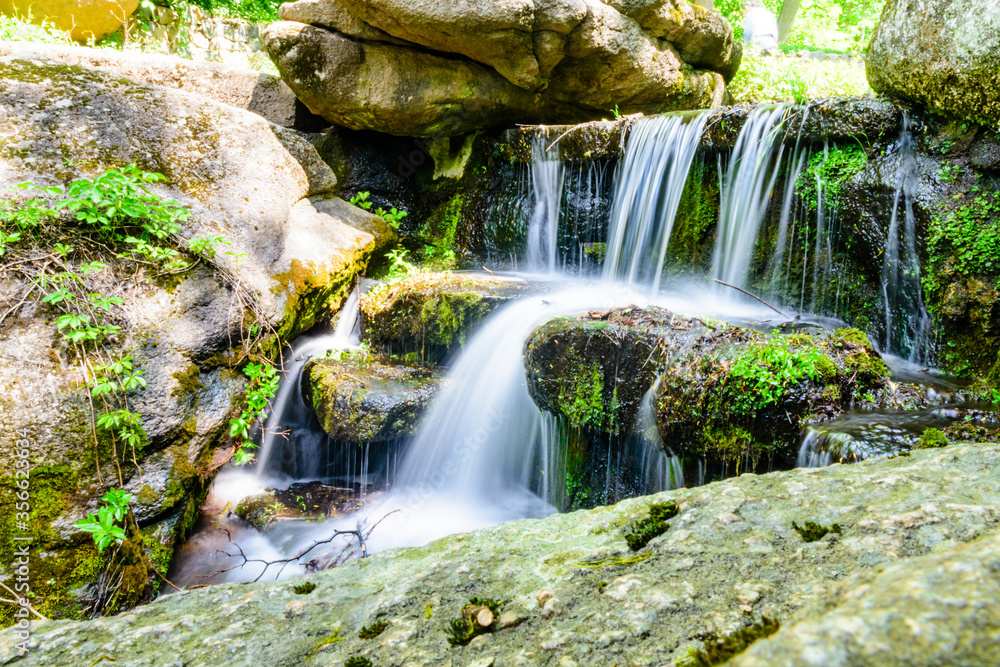 Beautiful waterfall on small river in a park Beautiful waterfall on small river in a park