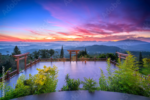 Dawn in front of temple gate with impressive colorful clouds in sky shines under mist valley to attract tourists to relax, meditate near Da Lat , Vietnam