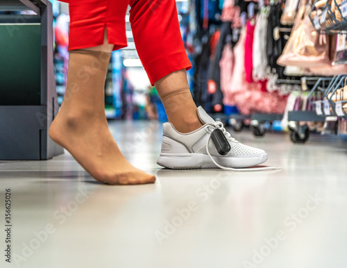 woman chooses and tries sports shoes in the store