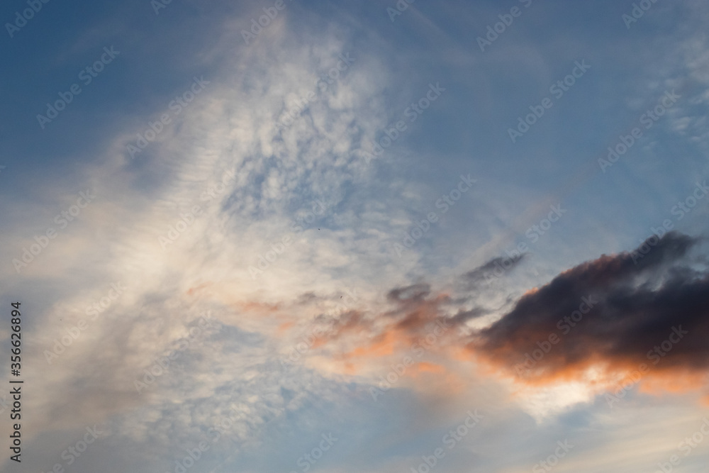 Light and dark clouds at sunset with blue sky background
