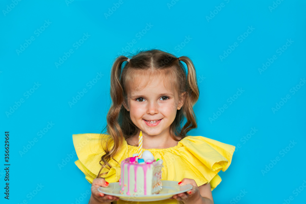 Young celebrating girl holding a piece of cake on blue background. Copy space Young celebrating girl holding a piece of cake on blue background. Copy space