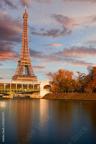 The eiffel tower at sunset from the other bank of the seine river and a view on the Bir Hakeim bridge