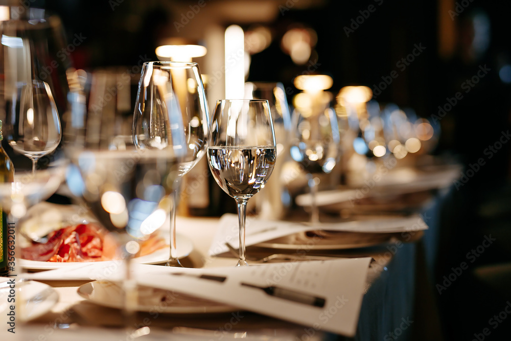 Holiday table set with goblets, luxury plates and candles