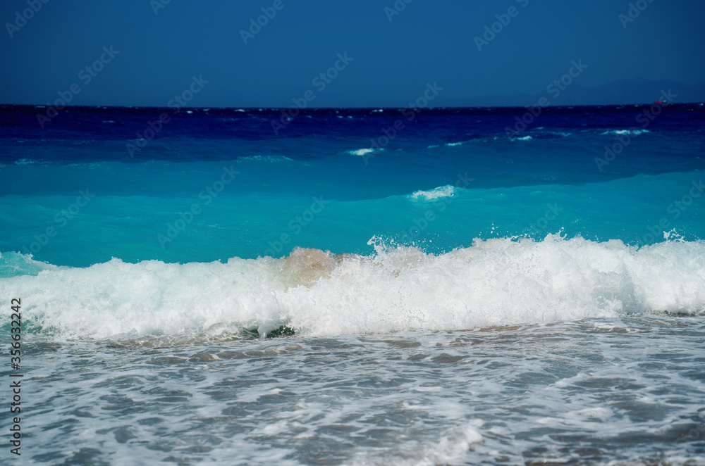 Peaceful sea wave foams on the beach, Aegean Sea, Rhodes, Greece. Peaceful sea wave foams on the beach, Aegean Sea, Rhodes, Greece.