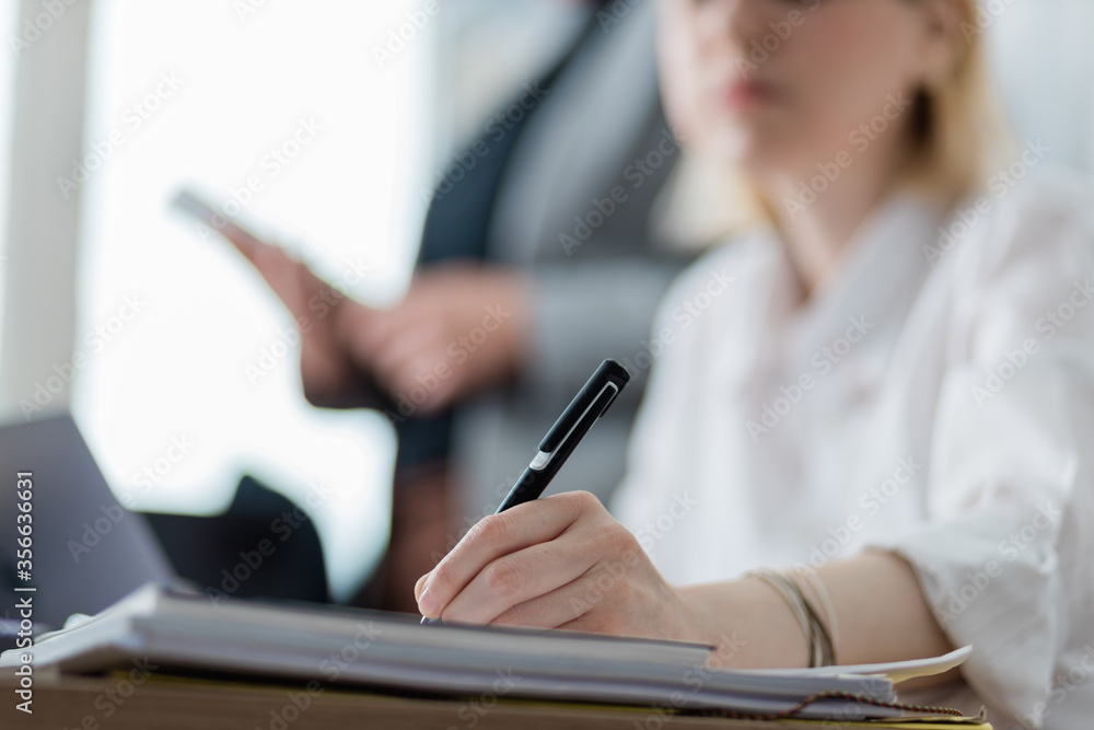 Young businesswoman signing a document in the office Young businesswoman signing a document in the office