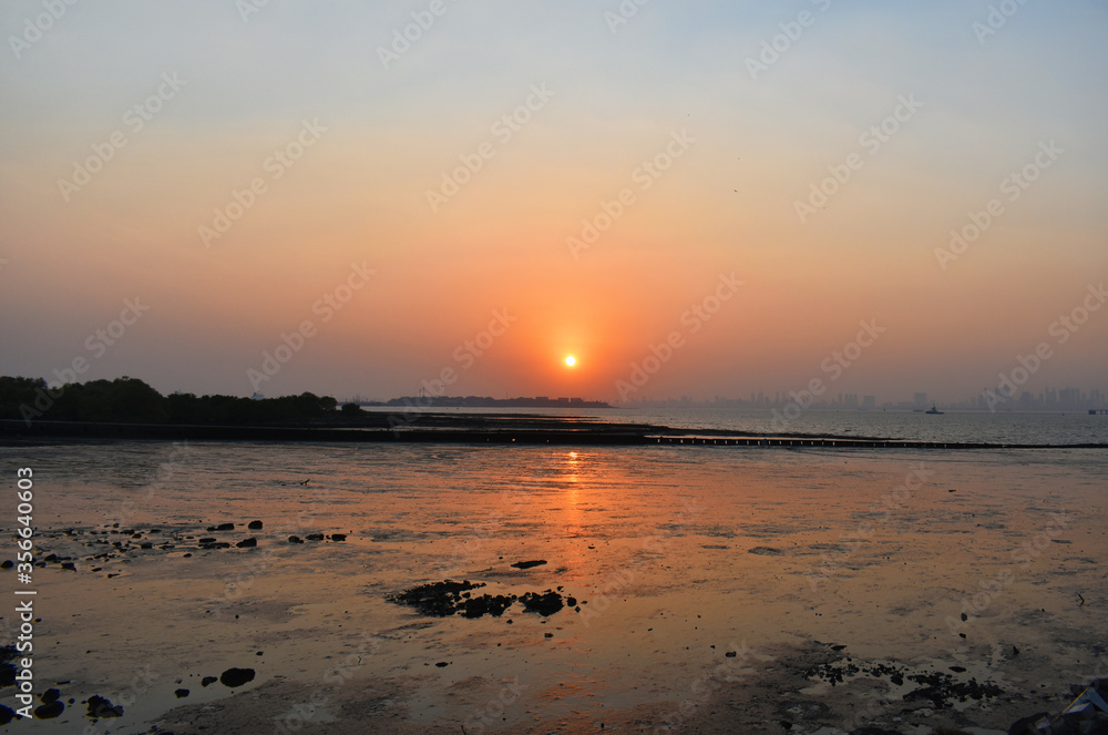 Sunset in the ocean with beautiful orange sky.