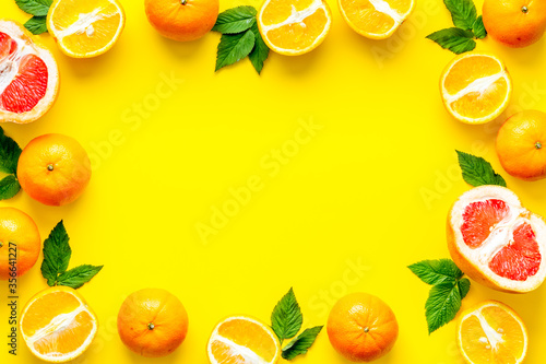Frame sliced citrus mix on yellow background top view