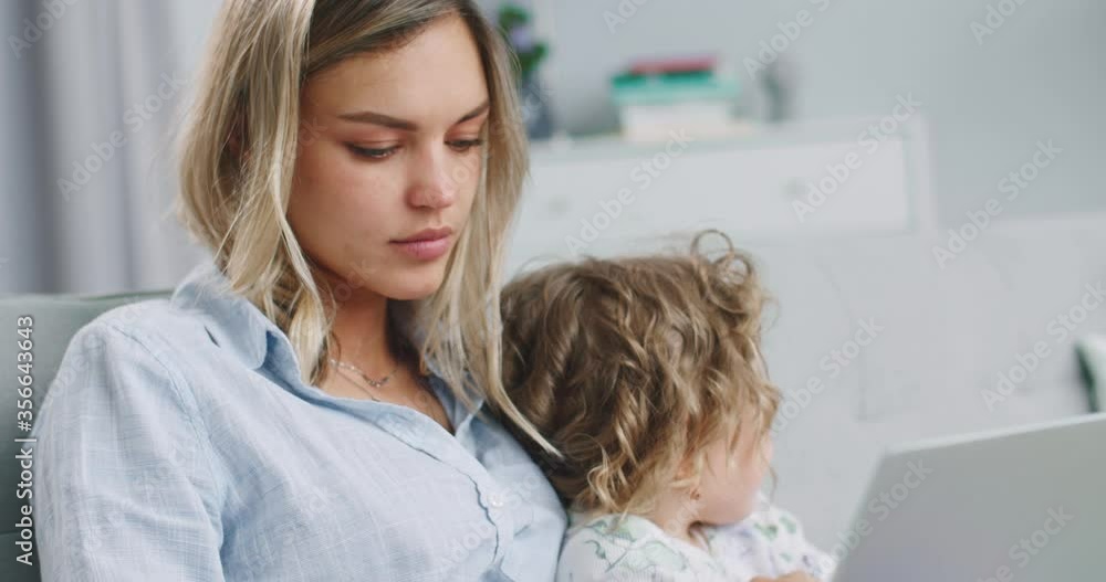 Middle plan of concentrated mum and daughter having fun using learning ...