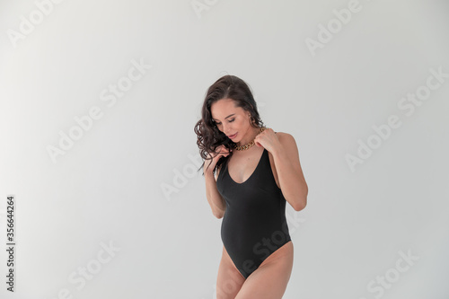 A fashion stylish pregnant sexual woman in Vogue style.glamorous Pregnant in a black bodiesuit