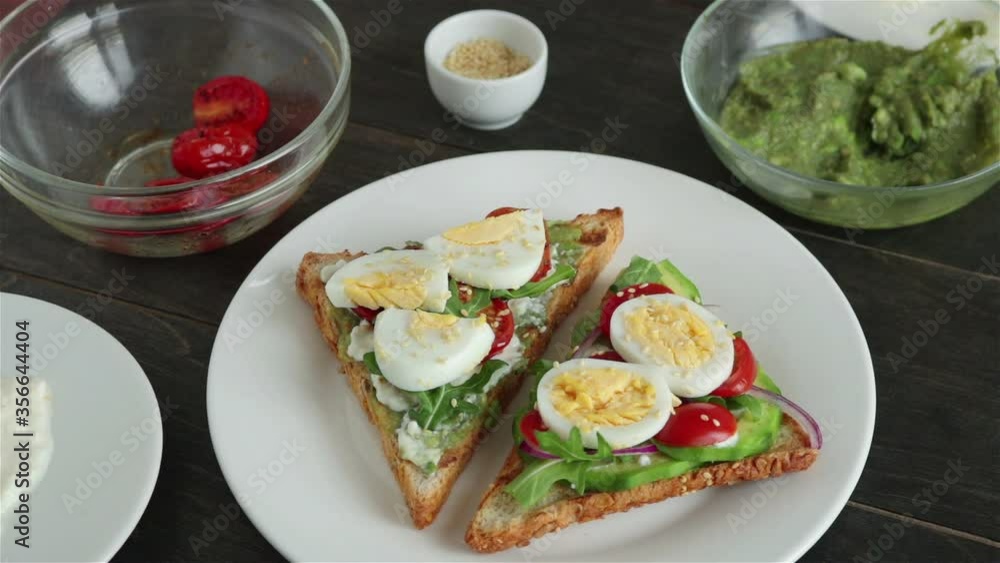 man put sandwich with avocado boiling egg cherry tomatoes arugula on white plate man put sandwich with avocado boiling egg cherry tomatoes arugula on white plate