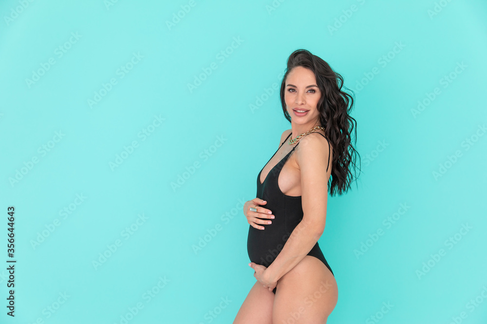 Sexy pregnant woman with long hair and in bidysuit (swimsuit) on a