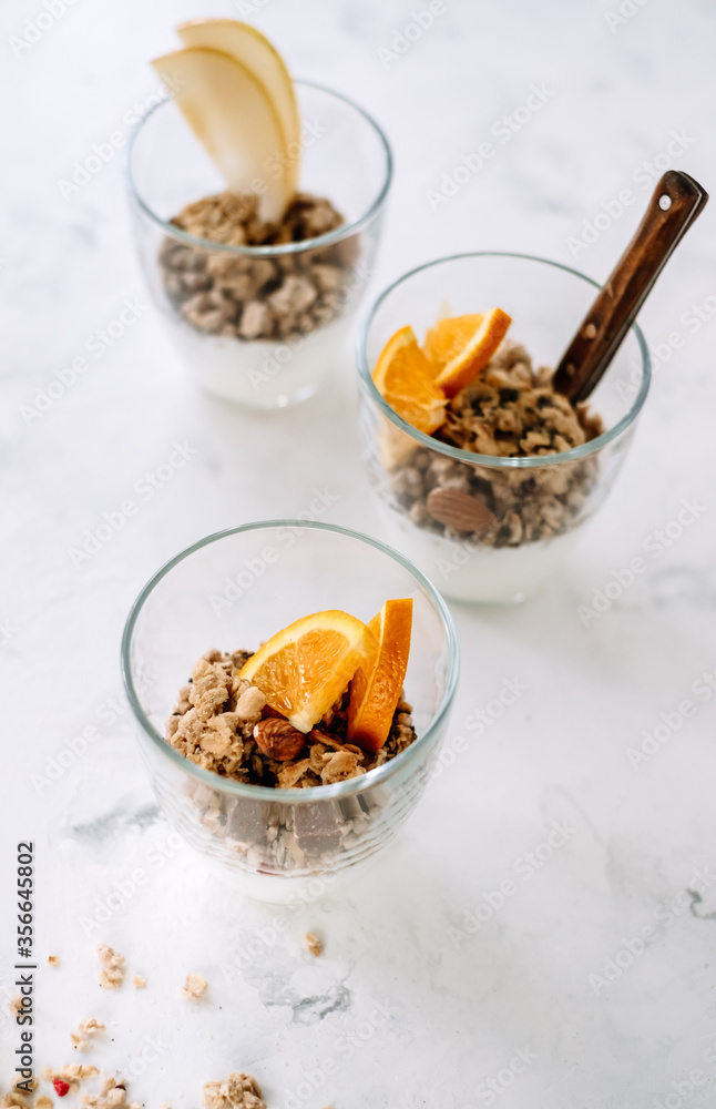 Granola and natural yogurt with slices of fruits and nuts in a glass cup, healthy breakfast. Granola and natural yogurt with slices of fruits and nuts in a glass cup, healthy breakfast.