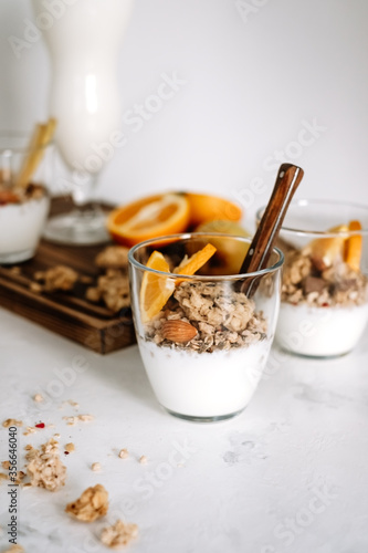 Granola and natural yogurt with slices of fruits and nuts in a glass cup, healthy breakfast.