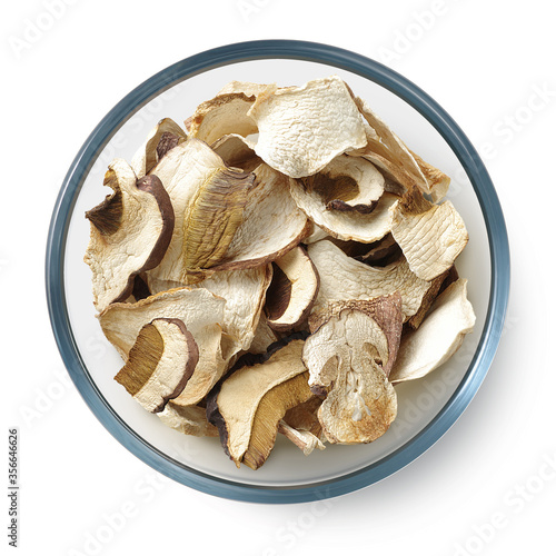 Dried white mushrooms in a glass dish on a white background. Isolated dried mushrooms. Top view.