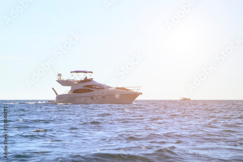 people sunbathe on a white yacht in the open sea