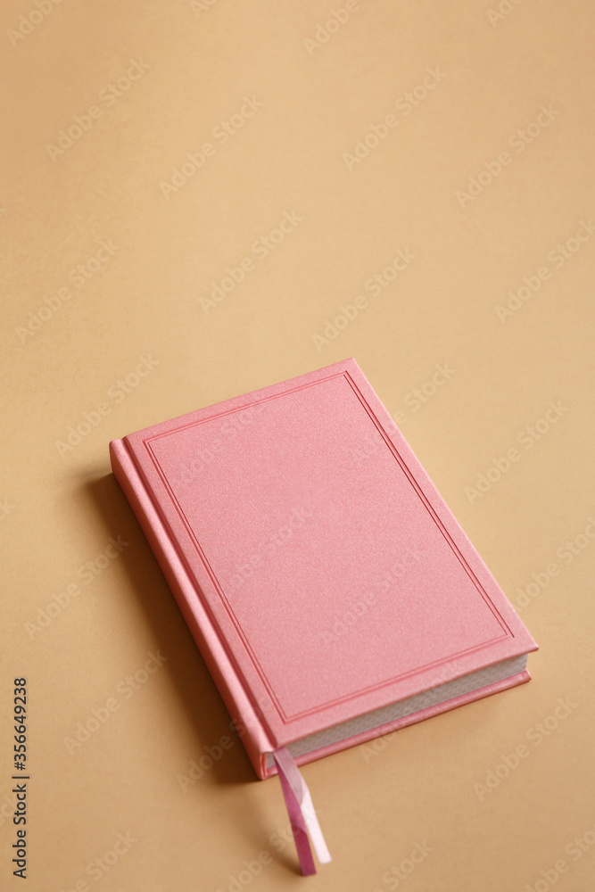 Fototapeta premium Cover of pink notebook, diary or book on brown paper background