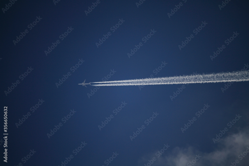 Plano de la estela de un avión, sobre cielo azul Plano de la estela de un avión, sobre cielo azul