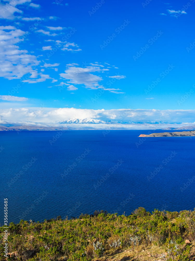 Lake Ticticaca on a sunny day with blue skies and clouds at the horizon Lake Ticticaca on a sunny day with blue skies and clouds at the horizon
