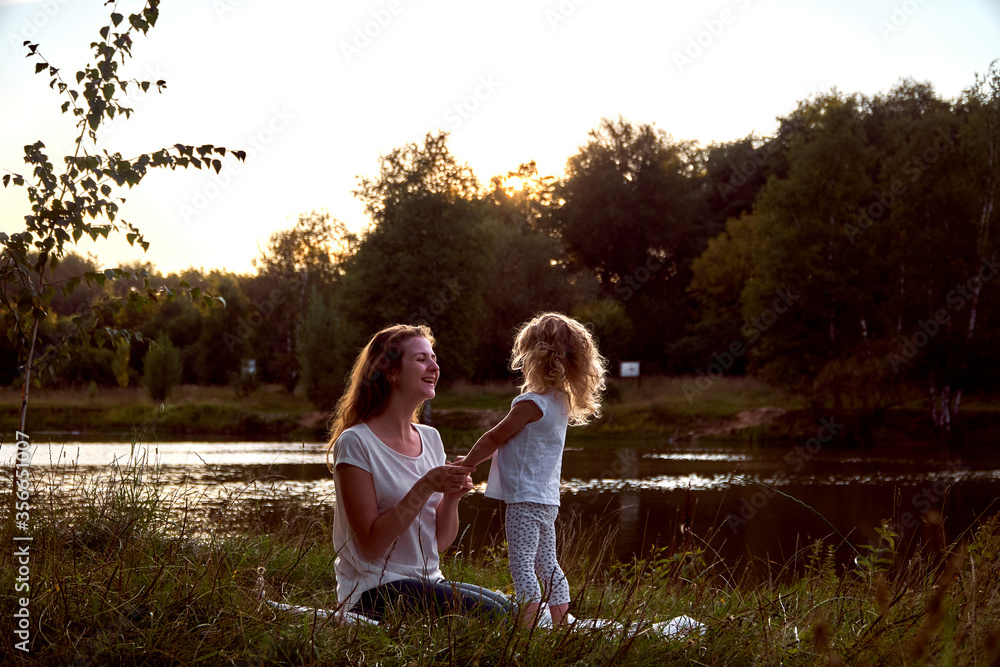 Mom and daughter on the street are looking at each other. Laughter and joy of a woman and a child. High quality photo Mom and daughter on the street are looking at each other. Laughter and joy of a woman and a child. High quality photo