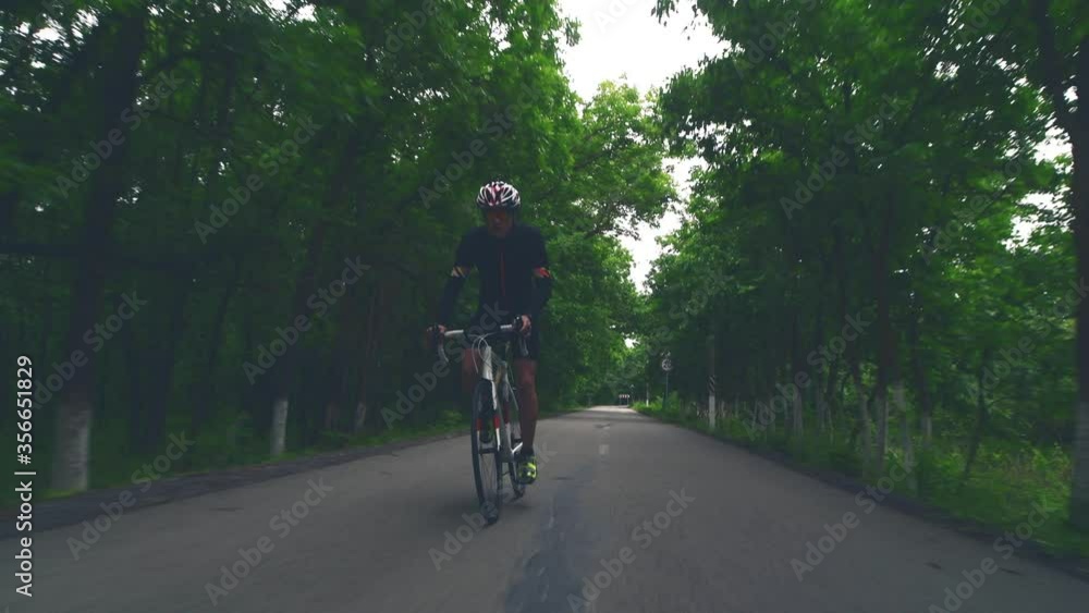 Pro bicyclist cycling road bike, sport concept, mountain road at sunset Pro bicyclist cycling road bike, sport concept, mountain road at sunset