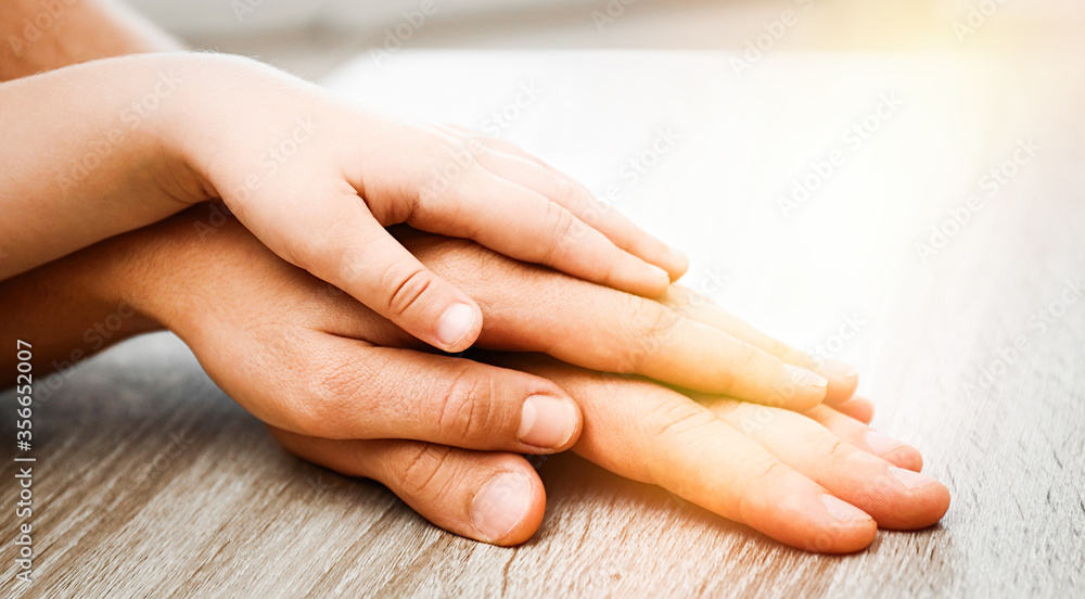 Naklejka premium Happy family holding hands at wooden table indoors, closeup. Banner design