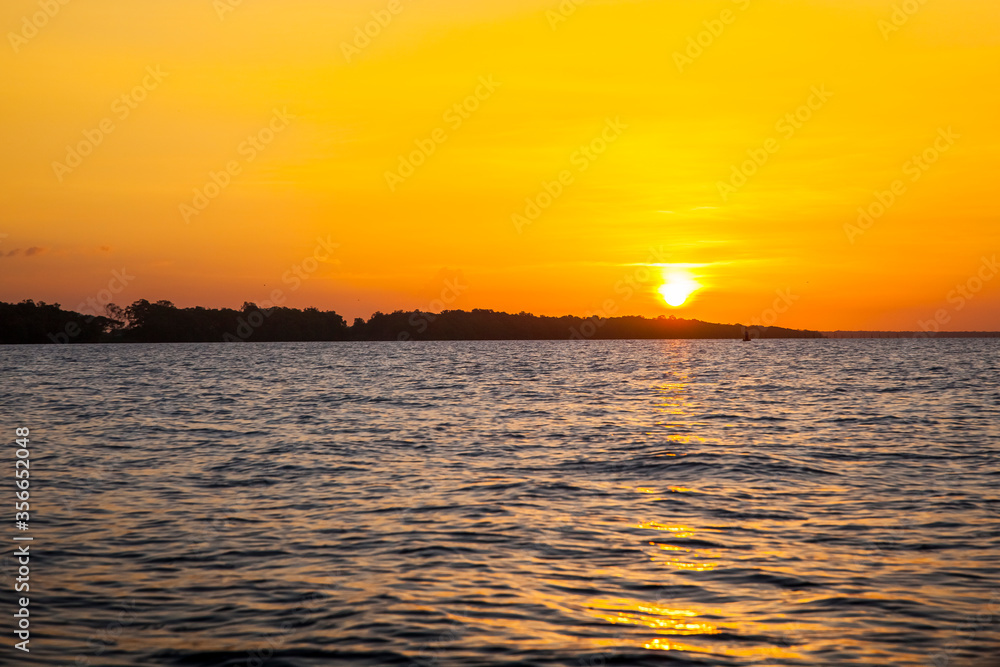 Obraz premium Sunset over the estuary of the Suriname river, Suriname