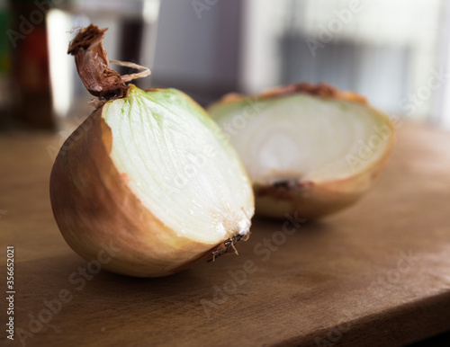 halves of ripe onions on wooden board