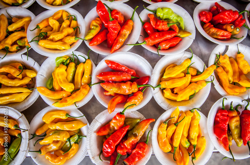 Cups with red and yellow peppers in a market stand in Paramaribo, Suriname.