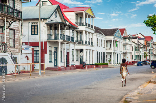 PARAMARIBO, SURINAME - OCTOBER 4, 2018: Old colonial buildings on Waterkant or Waterside street in the evening sun,a woman passing by