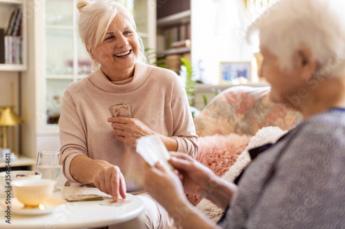 Fotografia Senior woman and her adult daughter playing cards at home