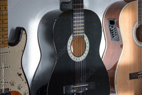 Acoustic and electric guitars hanging on a music room wall.