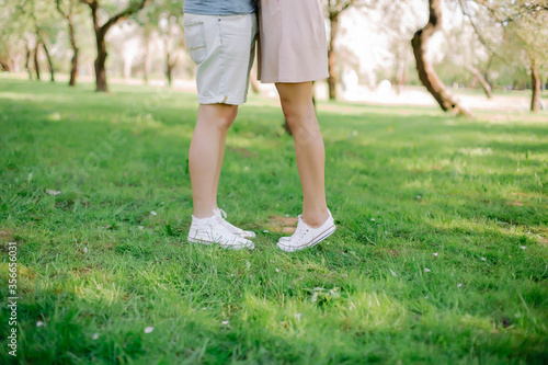Young couple walking in the park in summer holding hands