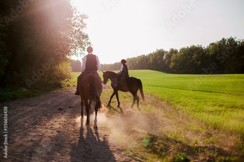 Young couple riding horses in the forest