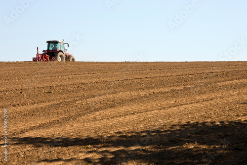 Agriculteur dans son tracteur qui travail la terre en France.