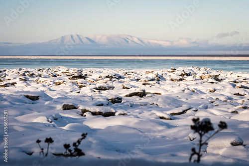 Beautiful winter landscape of a snowy mountain and frozen Knik Arm taken from Earthquake Park while following Tony Knowles Coastal Trail in Anchorage, Alaska. Snow. Ice floes melt. Near Woronzof Park. photo
