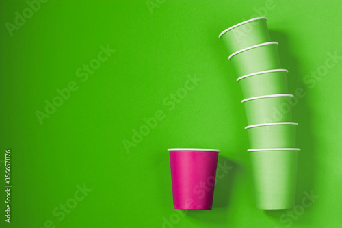 Paper cups on a green background. Ecological tableware. Minimalistic style. Top view. Copy space. © TATIANA