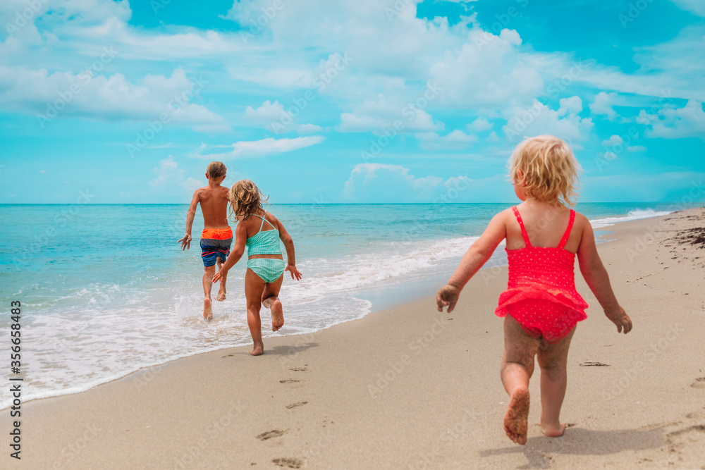 happy kids enjoy beach vacation, boy and girls have fun